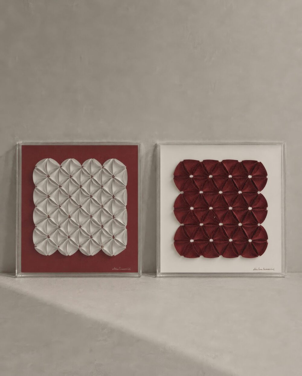 Díptico de dos cuadros en relieve, uno blanco y uno rojo sobre fondo burdeo
